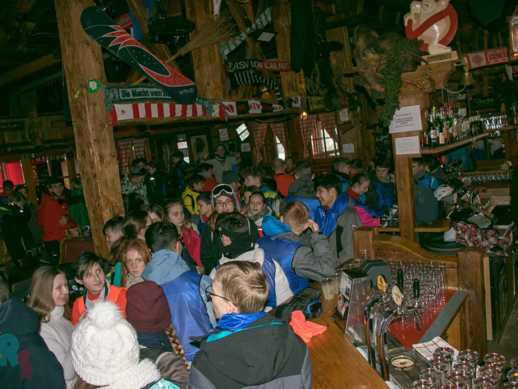Jugendliche stehen dicht gedrängt in der Skihütte.